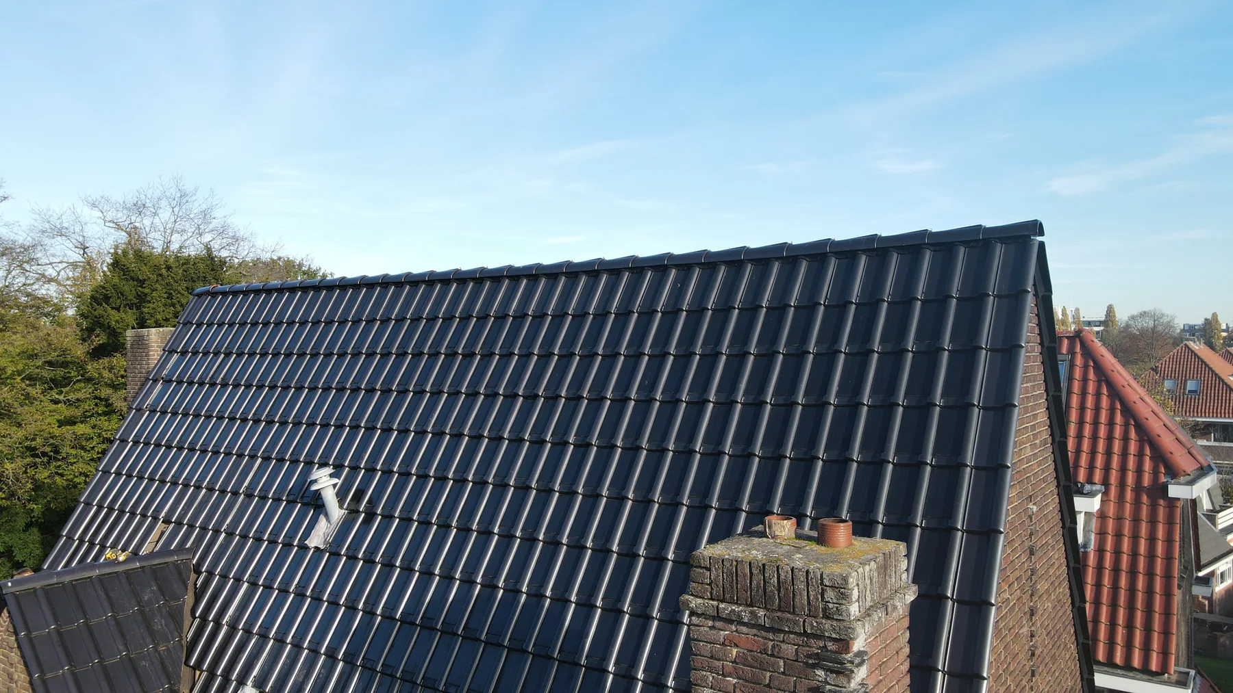 Compleet dak met zwarte zonnedakpannen en een rustig doorlopend legpatroon